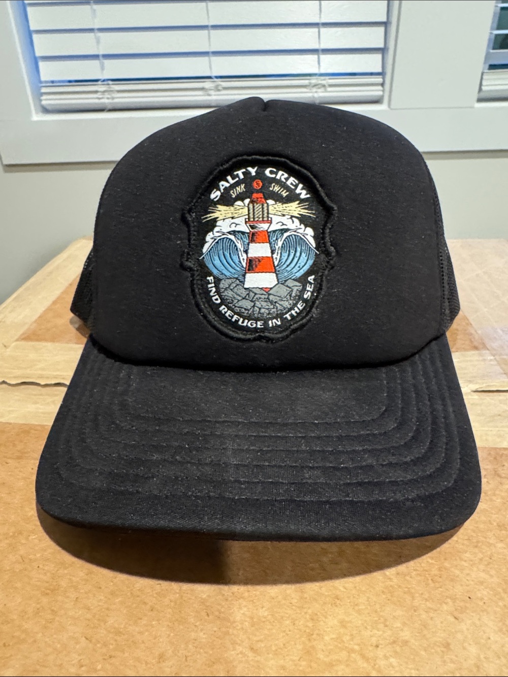 Salty Crew Black Trucker Hat with Red & White Lighthouse Patch